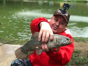 a man holding a large fish in his hands at Pesque pague pousada do Carlinho in Pinheiral