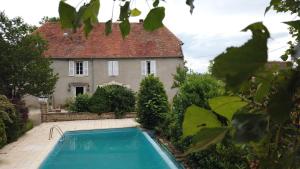 una casa con piscina di fronte a una casa di Le Cèdre Bleu - Maison d'hôtes 
