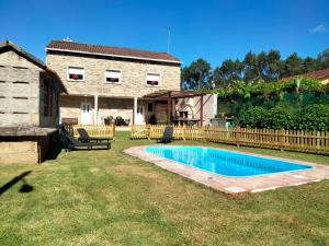 a backyard with a swimming pool and a house at Casa Da Pallota in Moraña