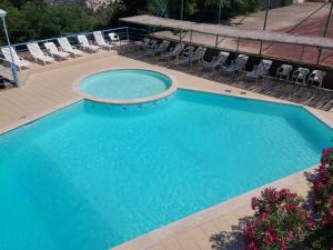 a swimming pool with chairs and a swimming pool at Hotel Villa Selene in Lanusei