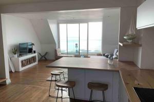 a kitchen with a counter and stools in a room at « Rêve de mer » appartement face mer in Le Portel