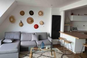 a living room with a couch and a table and a kitchen at « Rêve de mer » appartement face mer in Le Portel