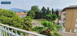 B&B La Corte Antica - Luino Lago Maggiore في لوينو: اطلالة البلكونة على مدينة فيها اشجار ومباني