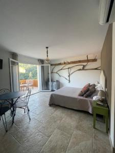 a bedroom with a bed with a tree branch on the wall at Chambre U Bugnu in Vico