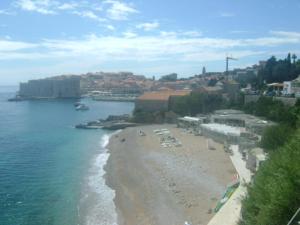 a beach with a group of people sitting on the sand at Studio Andrea in Dubrovnik