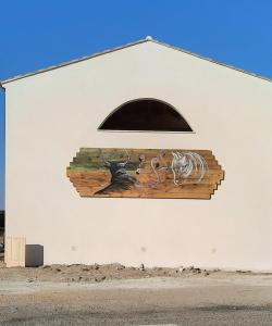 a mural on the side of a building with a window at Le Mas de Mon Pere in Saintes-Maries-de-la-Mer