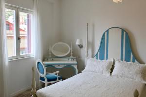 a bedroom with a bed with a mirror and a chair at Cetara Costa d'Amalfi Residence in Cetara