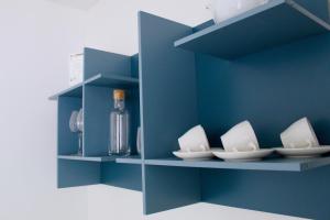 a shelf with white plates and a bottle on it at Cetara Costa d'Amalfi Residence in Cetara