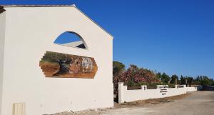 a white building with a painting on the side of it at Le Mas de Mon Pere in Saintes-Maries-de-la-Mer