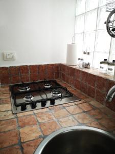 a stove top in a kitchen with a counter at La casa di Nì in Santa Teresa Gallura +23 photos