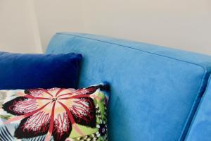 a blue couch with a flower pillow on it at Cetara Costa d'Amalfi Residence in Cetara