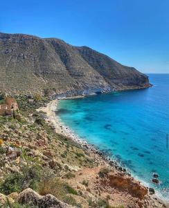 una playa de agua azul junto a una montaña en Isleta 5, en La Isleta del Moro