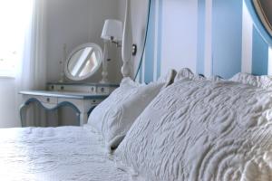a bedroom with a white bed with a mirror at Cetara Costa d'Amalfi Residence in Cetara
