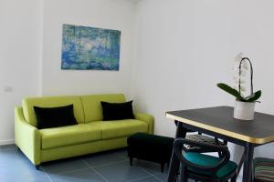 a living room with a green couch and a table at Cetara Costa d'Amalfi Residence in Cetara