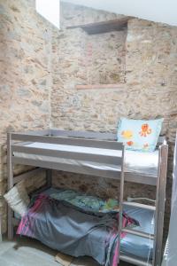 Ce lit superposé se trouve dans un dortoir doté d'un mur en briques. dans l'établissement Maison 3ch 65m2 en bord de mer, à Banyuls-sur-Mer
