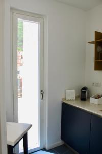 a kitchen with a counter and a door to a window at Cetara Costa d'Amalfi Residence in Cetara