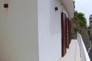 a white building with brown doors and a walkway at Cetara Costa d'Amalfi Residence in Cetara