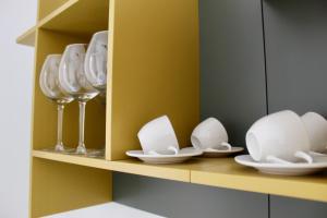 a shelf with plates and wine glasses on it at Cetara Costa d'Amalfi Residence in Cetara