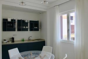 a kitchen with a glass table and white chairs at Cetara Costa d'Amalfi Residence in Cetara