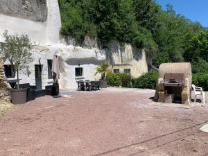 a building with a table and chairs in front of it at Au Petit Nice in Nazelles