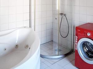 a bathroom with a tub and a washing machine at 6 person holiday home in Dannemare in Dannemare