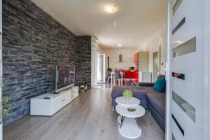a living room with a blue couch and a brick wall at Apartment A & J in Petrcane