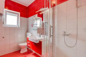 a red bathroom with a sink and a shower at Apartment A & J in Petrcane +25 photos