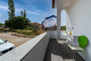 a balcony with a table and chairs and an umbrella at Apartment A & J in Petrcane