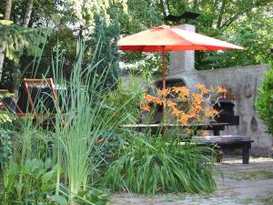 una mesa con sombrilla en un jardín en Les Gîtes de l'Escalier, en Brumath