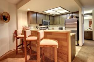 een keuken met een tafel en stoelen en een koelkast bij Giant Steps 34 Ski In-out in Brian Head