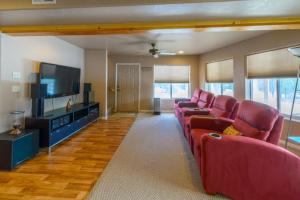 a living room with red chairs and a flat screen tv at Kool Kabin in Duck Creek Village