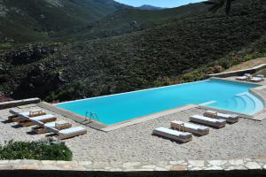 an image of a swimming pool with lounge chairs at Aegea Blue Cycladic Resort in Zorgos 