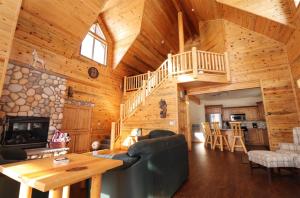 una sala de estar con una escalera en una cabaña de madera en Altitude Adjustment, en Duck Creek Village