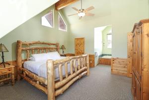1 dormitorio con cama de madera y ventilador de techo en Altitude Adjustment, en Duck Creek Village