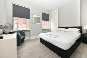 ein Schlafzimmer mit einem großen Bett und einem Schreibtisch in der Unterkunft Soho Apartment, Piccadilly & Regent Street in London