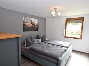 sypialnia z łóżkiem i zdjęciem jelenia w obiekcie Spacious holiday home with private terrace w mieście Hasselfelde