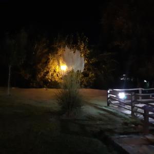 un parque de noche con una valla y luces en Refugio de las Sierras en Villa General Belgrano
