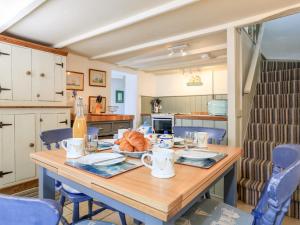 eine Küche mit einem Holztisch mit Croissants darauf in der Unterkunft Elworthy Cottage in Salcombe