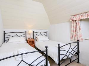 2 Einzelbetten in einem Zimmer mit Fenster in der Unterkunft Elworthy Cottage in Salcombe
