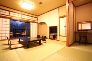 a living room with a table and a tv at Yumerindo in Minamioguni