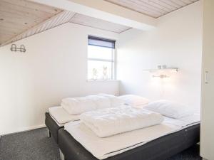 a bedroom with white walls and a bed with white sheets at Tranquil Oasis in Henne Strand-By Traum in Henne Strand +58 photos