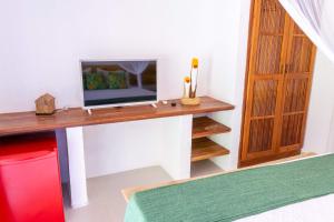 a room with a desk with a television on it at Pousada Rio da Vila in Porto Seguro