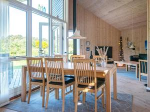 Fjand Gårdeにある8 person holiday home in Ulfborgのダイニングルーム(木製テーブル、椅子付)