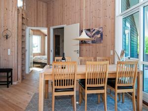 Fjand Gårdeにある8 person holiday home in Ulfborgのダイニングルーム(木製テーブル、椅子付)