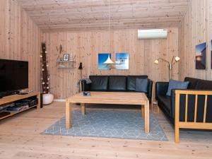 a living room with a couch and a coffee table at 8 person holiday home in Ulfborg in Fjand Gårde
