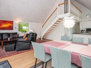 een eetkamer en een woonkamer met een tafel en stoelen bij 6 person holiday home in R m in Toftum