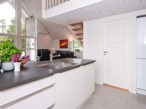 een keuken met witte kasten en een wastafel bij 6 person holiday home in R m in Toftum