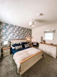 a bedroom with a large bed with a floral accent wall at Luxury Sea View Apartment in Portrush