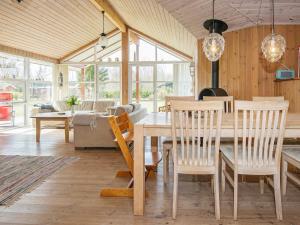 a dining room and living room with a table and chairs at 8 person holiday home in Glesborg in Glesborg