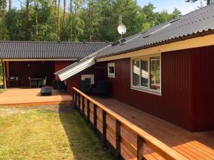 a house with a wooden deck next to a building at 8 person holiday home in Nex in Vester Sømarken